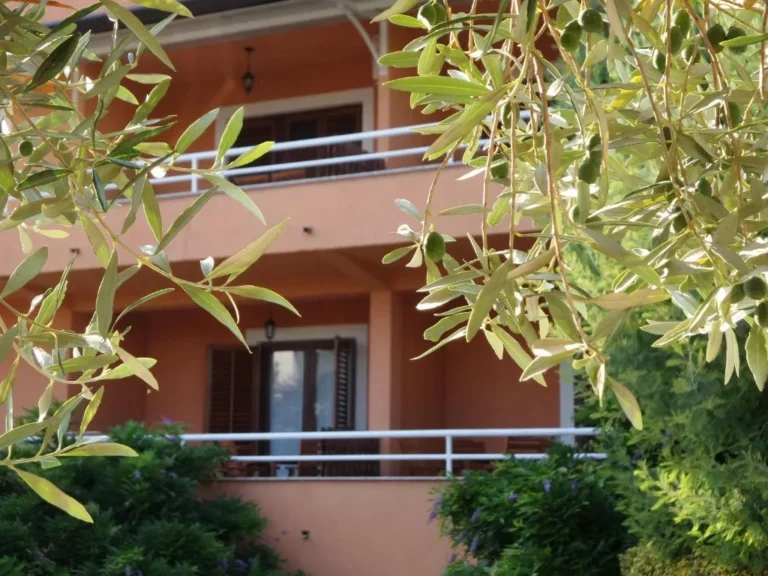 Pročelje kuće s balkonima u zelenilu